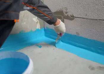 The waterproofing coating is blue. Cover the concrete wall with a cement-polymer waterproofing membrane. Waterproofing with a blue shade brush.