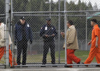 Inmates walk past correctional officers at the Washington Corrections Center in Shelton, Wash., in 2011. Gov. Jay Inslee said Tuesday that more than 3,000 prisoners in Washington have been mistakenly released early since 2002 because of an error by the state's Department of Corrections.